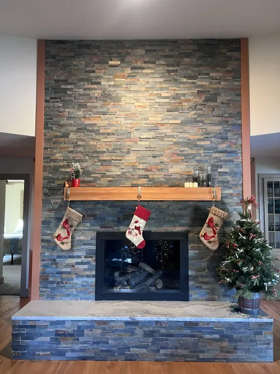 Stone ledger fireplace wall with wood mantel and finished hearth in Jacksonville, FL