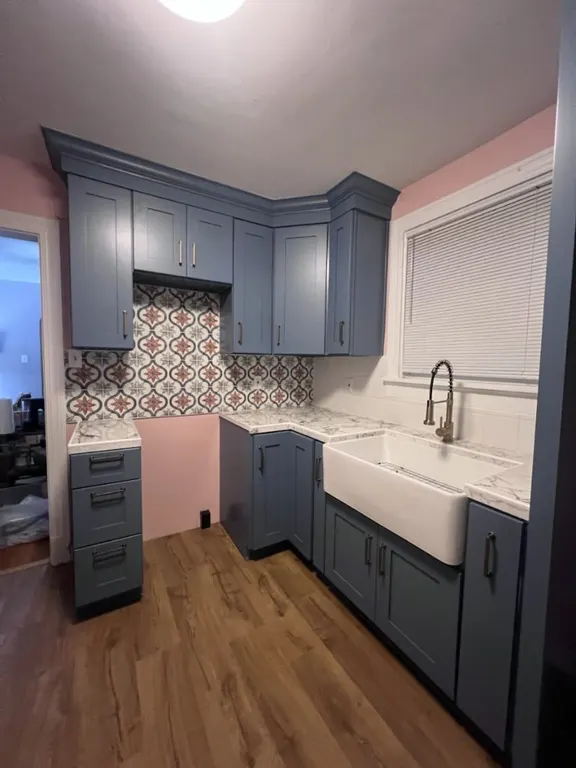 Kitchen remodel with gray cabinets, patterned backsplash, counters, sink, and flooring in Jacksonville, FL by Heylo Home