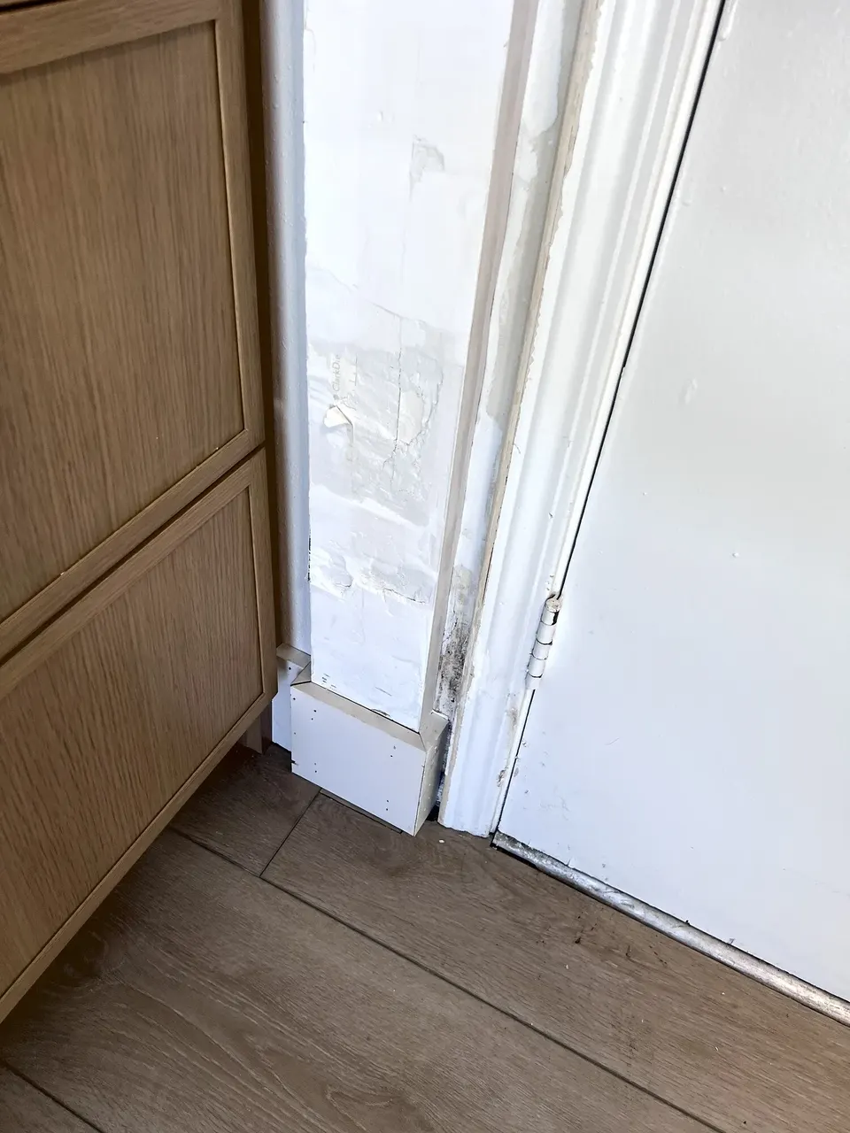 Unfinished wall opening above the built-in coffee-bar cabinetry before drywall repair