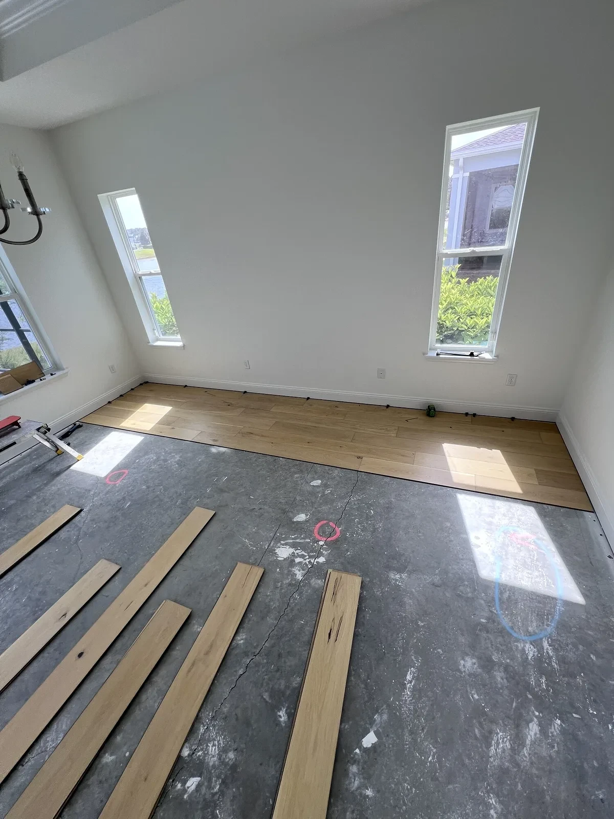 Engineered hardwood installation progressing across a prepared room