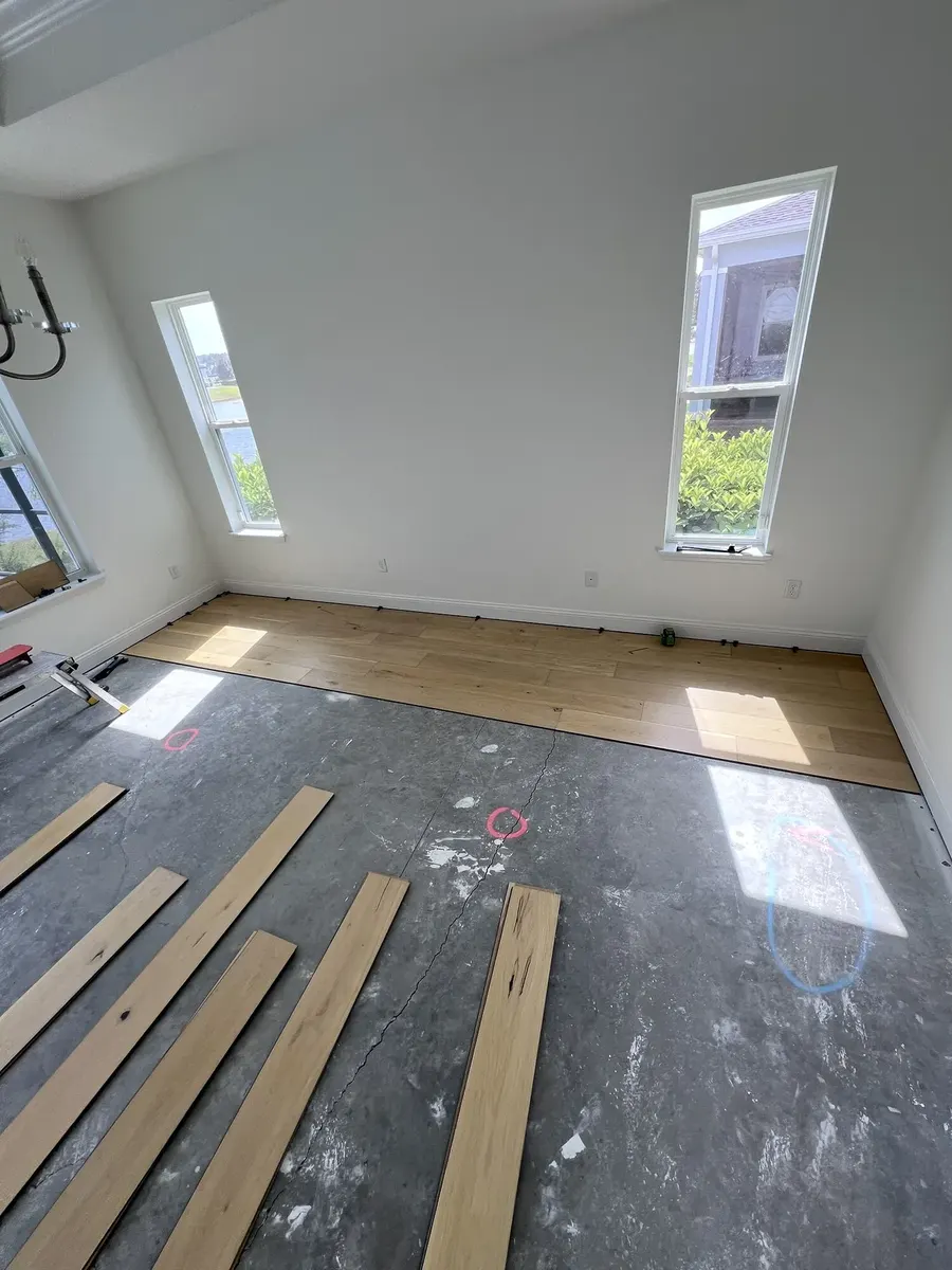 Engineered hardwood installation progressing across a prepared room