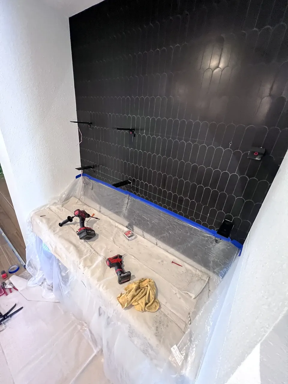 Steel shelf brackets installed through the tile
