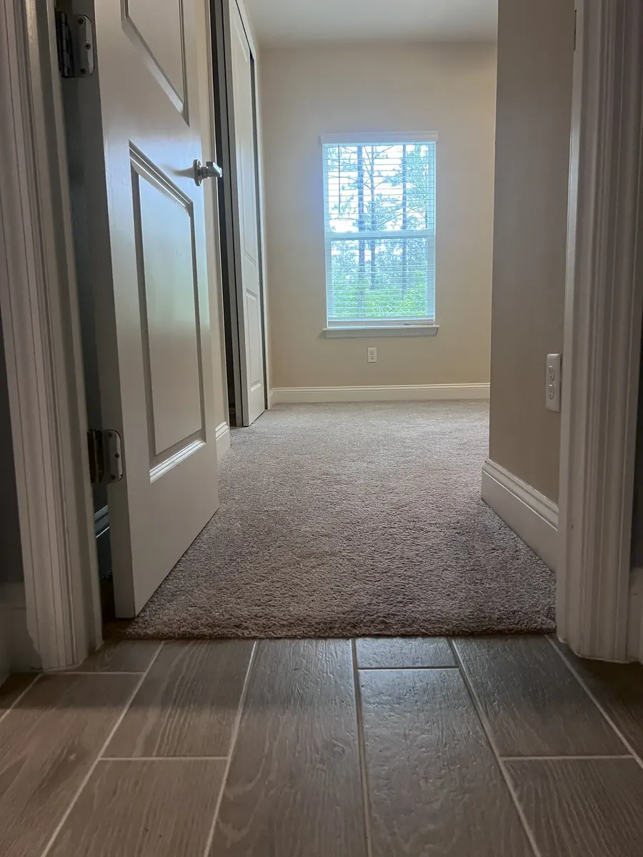 Carpeted bedroom doorway before flooring removal