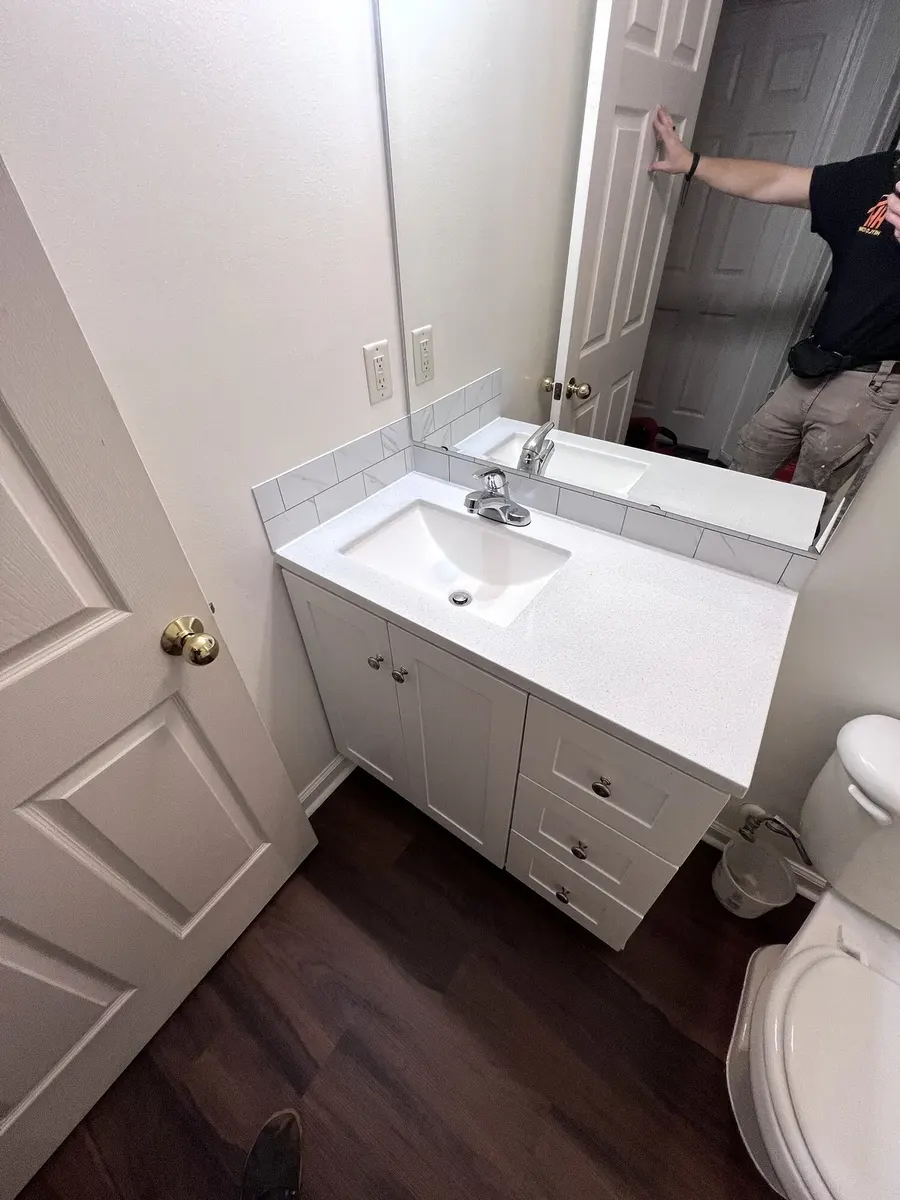 Completed hall bathroom vanity, mirror, and floor