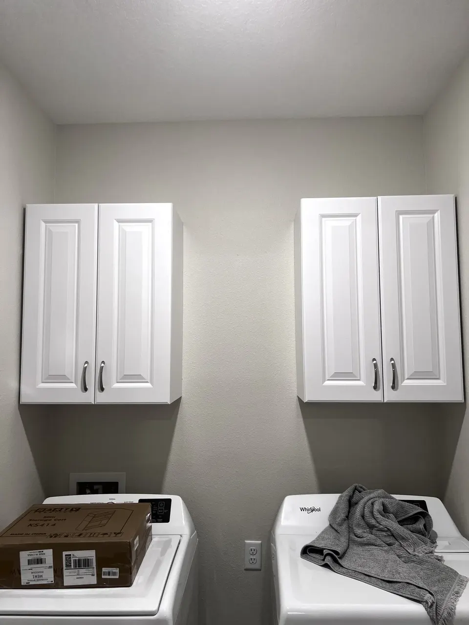 Finished white wall cabinets above a Yulee laundry area
