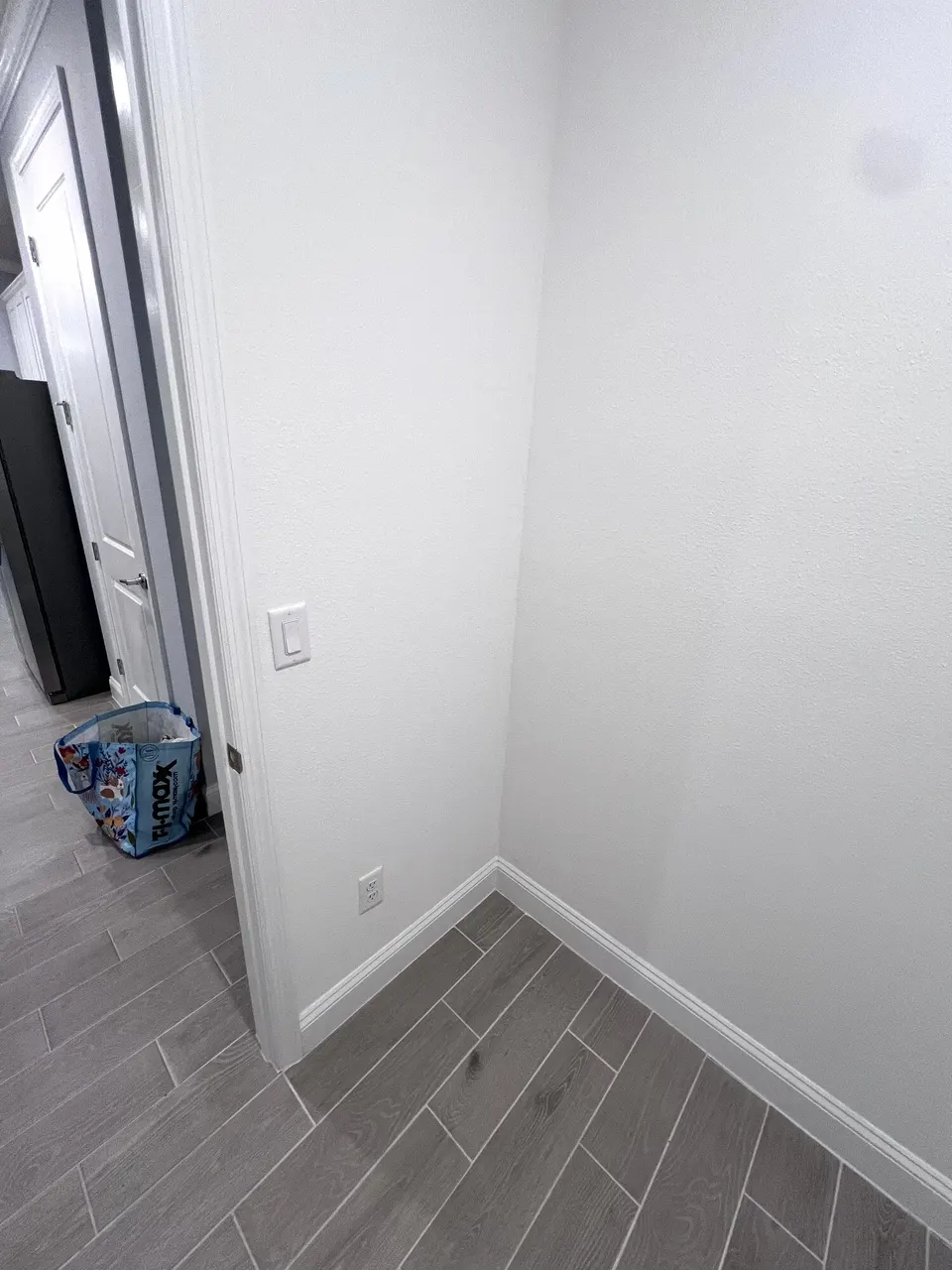 Empty wall beside the utility room before the tall cabinet installation