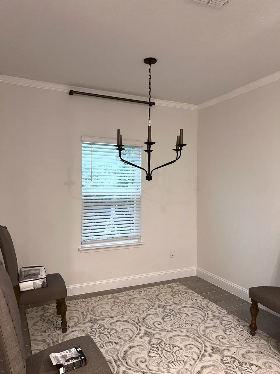 Installed chandelier and curtain rod in a finished room